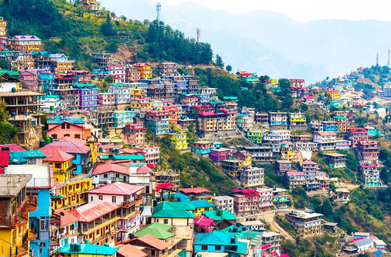 A hillside in Shimla, India, lined with bright, colourful buildings