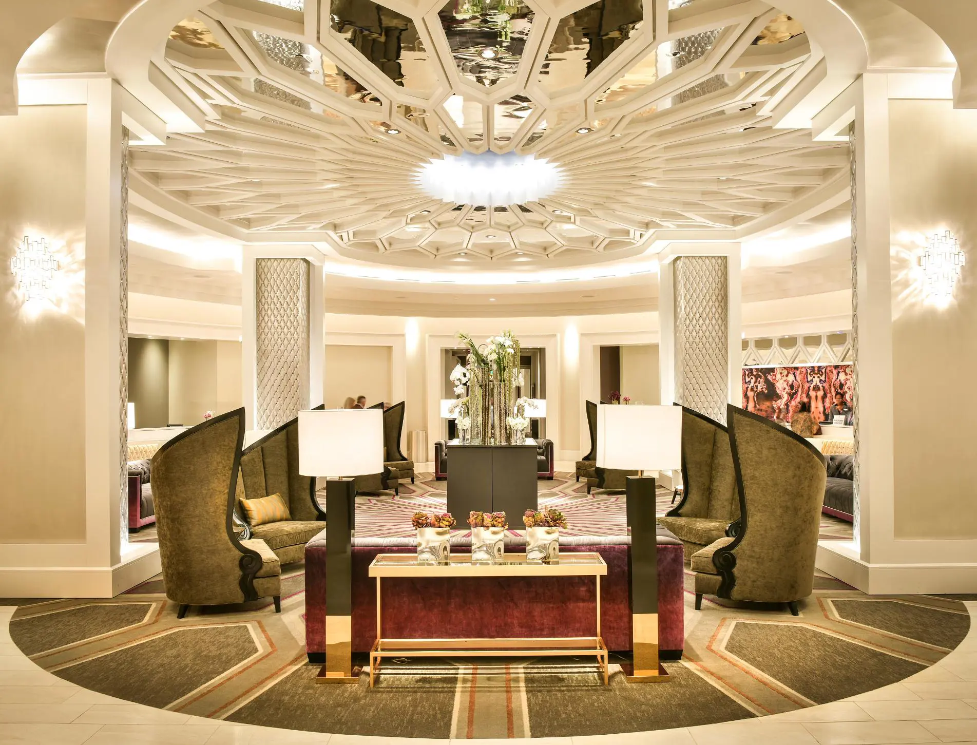 The ornate lobby at The Guest House at Graceland, featuring high-backed chairs, modern lighting, and a stunning patterned ceiling